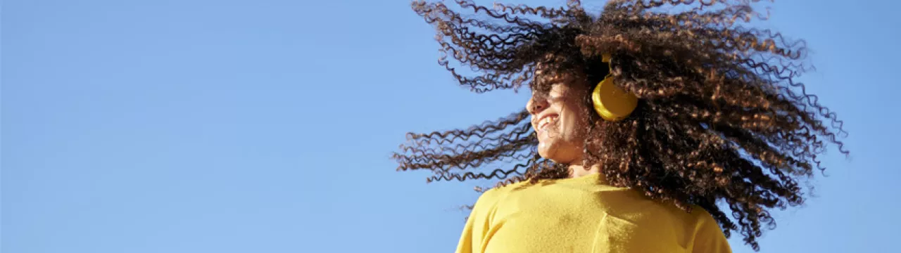 Happy woman with wild hair listening to music